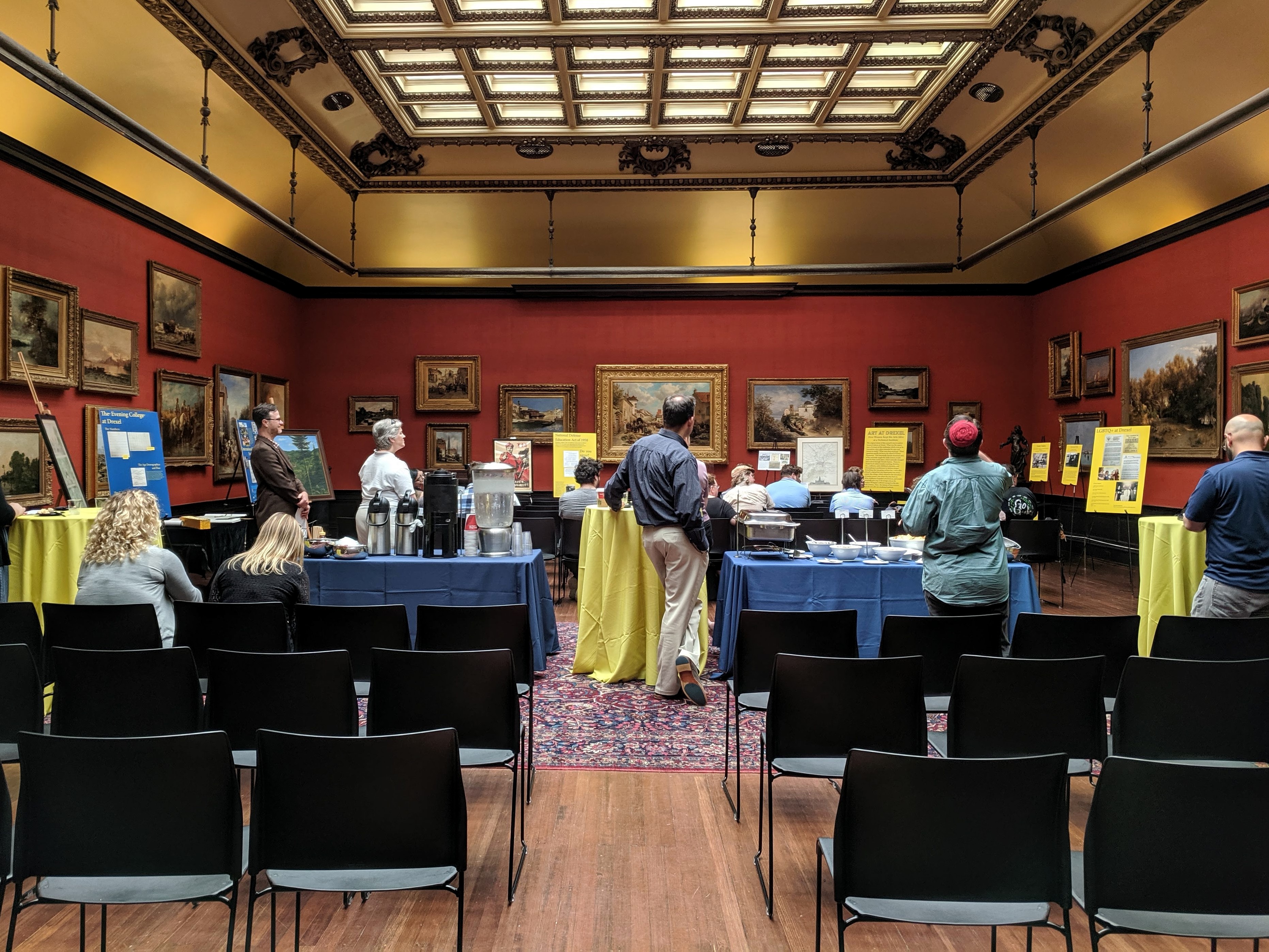People stand around posters in the AJ Drexel Picture Gallery